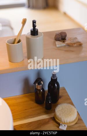 Gli accessori naturali per il bagno sono disposti in modo ordinato su un ripiano in legno in una casa accogliente Foto Stock