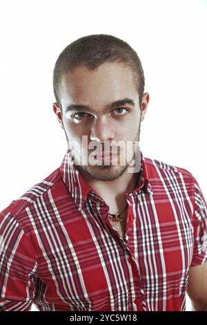 Giovane uomo sicuro di sé con camicia a quadri rossa, massima espressione, stile alla moda. Capelli corti, occhi verdi, peli corti. Atmosfera maschile e moderna per una visione millenaria Foto Stock