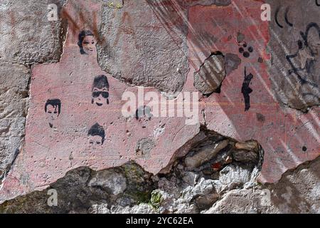 Dettaglio di un vecchio muro in rovina con silhouette a stencil nere su sfondo rosa spruzzato, Sestri Levante, Genova, Liguria, Italia Foto Stock