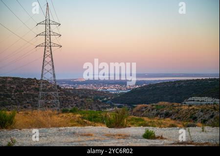 Si tratta di un'immagine di una torre di trasmissione elettrica ad alta tensione, nota anche come un pilone o linee elettriche aeree, al tramonto Foto Stock