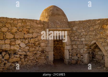 Un'antica entrata in pietra caratterizzata da una struttura a cupola sopra la porta, parte di un edificio tradizionale a Creta, in Grecia. Le solide pareti in pietra e la Foto Stock