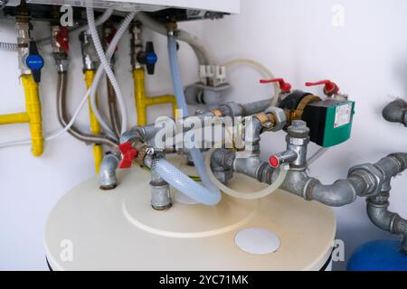 Installazione di acqua calda e gas in una casa, con serbatoio dell'acqua e tubi. Foto Stock