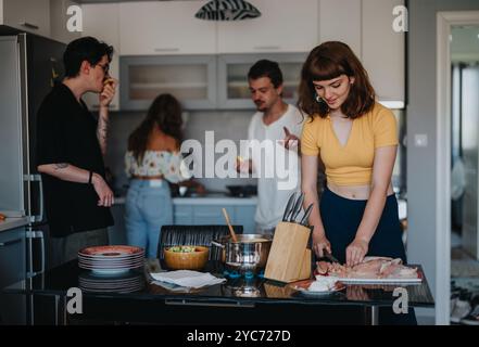 Amici che si godono una sessione di cucina informale in una cucina moderna Foto Stock