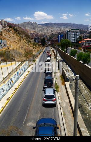 La Paz, BOLIVIA; 21 ottobre 2024: La coda dei veicoli per il rifornimento di benzina/benzina presso la stazione di servizio Virgen de los Álamos in Av Los Álamos ai piedi di Calacoto nella zona Sur. Questa immagine è stata scattata all'incrocio tra Calle 13 de Calacoto e Av Costanera, a 7/8 isolati di distanza. Le carenze di carburante e i problemi di alimentazione (in particolare il diesel) sono stati un problema regolare in Bolivia per diversi mesi. Dall'inizio della scorsa settimana, ci sono state enormi code anche per benzina/benzina, in parte a causa dei blocchi stradali sull'autostrada principale da Arica, Cile, attraverso i quali viene importato un po' di carburante. Foto Stock