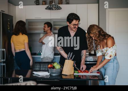 Amici che si godono una sessione di cucina informale in cucina Foto Stock