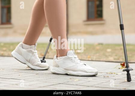 Donna sportiva che fa nordic walking per strada, primo piano Foto Stock