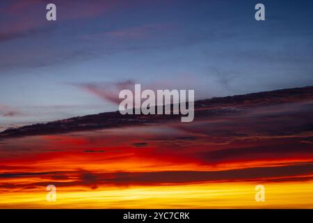 Vivi un tramonto mozzafiato con colori vivaci e ricchi che dipingono l'ampio cielo Foto Stock