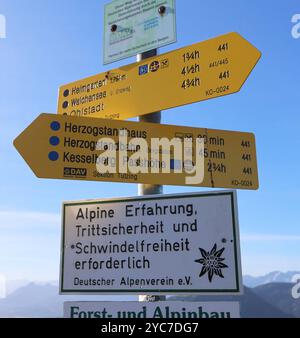 Herzogstand, Bayern, Deutschland, 21 anni. Oktober 2024: Ein Herbsttag am Herzogstand Gemeinde KochelLandkreis Bad Tölz-Wolfratshausen. Hier der Blick auf Wegschilder, Schilder, Wegweiser zum Heimgarten, Walchensee, dazu ein Hinweisschild, Warnschild, Alpine Erfahrung, Trittsicherheit und Schwindelfreiheit erforderlich vom DAV, Deutscher Alpenverein Bayerische Voralpen, Wandern, Bergwandern, Alpen, hoch über dem Walchensee, Zweiseenland, spazieren, Herbst, herbstlich, Sonnenwetter, Ausflugswetter, München Hausberg *** Herzogstand, Baviera, Germania, 21 ottobre 2024 un giorno d'autunno a Herzogstand muni Foto Stock