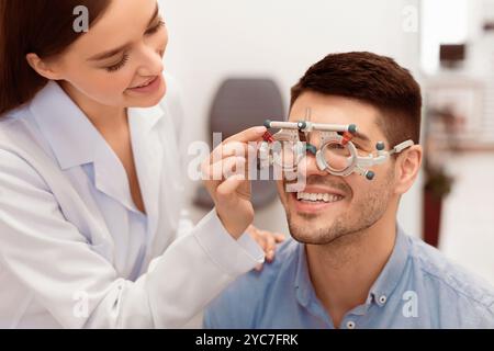 Visione dei pazienti con controllo da parte dell'optometro con struttura di prova in clinica Foto Stock