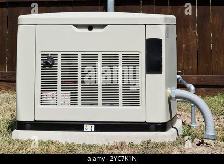 Gruppo elettrogeno domestico di standby in cortile residenziale, alimentazione elettrica di riserva di emergenza generazione di elettricità. Foto Stock