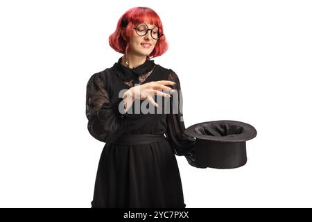 Maga con un cappello che esegue un trucco magico isolato su sfondo bianco Foto Stock