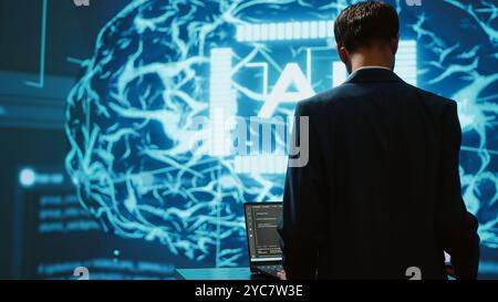 Dipendente della startup che guarda i grafici aziendali, utilizza il software di intelligenza artificiale per prendere decisioni basate sui dati nel settore tecnologico. Esperto IT che sviluppa soluzioni innovative di intelligenza artificiale per l'azienda, la fotocamera A. Foto Stock