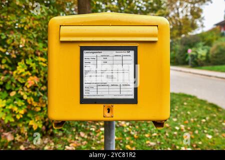 Bad Birnbach, Baviera, Germania - 21 ottobre 2024: Una casella letteraria gialla Deutsche Post con tempi di svuotamento chiaramente visibili. I clienti possono inviare lettere e articoli che vengono regolarmente raccolti dall'ufficio postale qui *** Ein gelber Briefkasten der Deutschen Post mit gut sichtbaren Leerungszeiten. Kunden können hier ihre Briefe und Sendungen einwerfen, die regelmäßig von der Post abgeholt werden Foto Stock