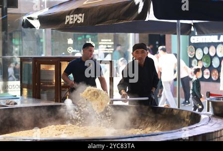 Tashkent, Uzbekistan - settembre 29 2024: Lo chef ha sparato il plov o il pilau in cucina. Il plov è uno dei piatti famosi dell'Asia centrale che di solito involv Foto Stock