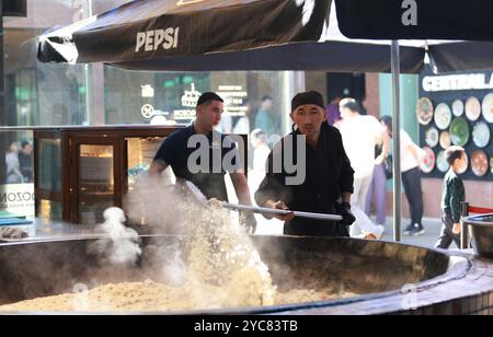 Tashkent, Uzbekistan - settembre 29 2024: Lo chef ha sparato il plov o il pilau in cucina. Il plov è uno dei piatti famosi dell'Asia centrale che di solito involv Foto Stock