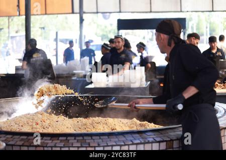 Tashkent, Uzbekistan - settembre 29 2024: Lo chef ha sparato il plov o il pilau in cucina. Il plov è uno dei piatti famosi dell'Asia centrale che di solito involv Foto Stock