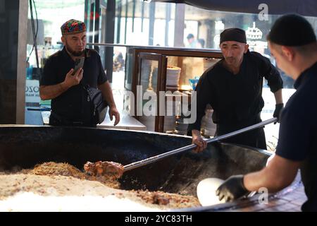 Tashkent, Uzbekistan - settembre 29 2024: Lo chef ha sparato il plov o il pilau in cucina. Il plov è uno dei piatti famosi dell'Asia centrale che di solito involv Foto Stock