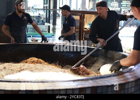 Tashkent, Uzbekistan - settembre 29 2024: Lo chef ha sparato il plov o il pilau in cucina. Il plov è uno dei piatti famosi dell'Asia centrale che di solito involv Foto Stock