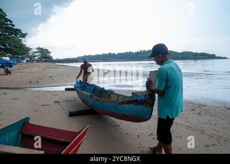 I pescatori stanno cercando di spostare le loro barche sulla spiaggia di Balikpapan Foto Stock