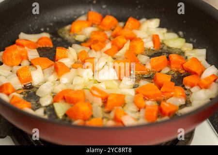 Le cipolle finemente tritate e le carote fresche vengono fritte nel burro e preparate con patè Foto Stock