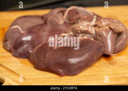 Fegato di tacchino crudo fresco su un tagliere, primo piano Foto Stock