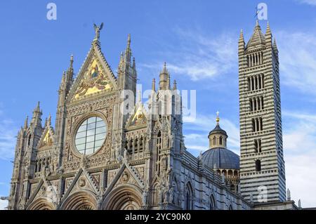 La facciata principale, la cupola e la torre della Cattedrale di Siena (Duomo) sotto poche nuvole e un cielo blu, Italia, Europa Foto Stock