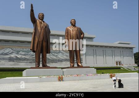 08.08.2012, Pyongyang, Corea del Nord, Asia, due nordcoreani si inchinano davanti alle gigantesche statue di bronzo degli ex leader nordcoreani Kim il-Sung e Ki Foto Stock