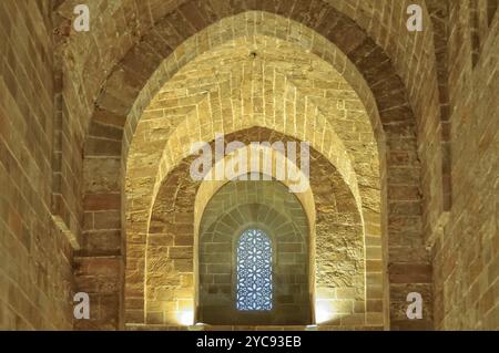 Semplici muri e archi in pietra e una finestra in stile arabo nella Cappella reale (Cappella Palatina) del Palazzo dei Normanni (Palazzo dei Normanni), Palermo, Foto Stock