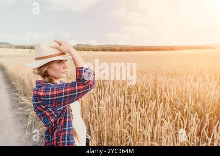 Donna campo di grano. Agronomo, agricoltore donna che controlla i picchi d'orzo maturo dorato nel campo coltivato. Primo piano della mano femminile sulla piantagione in agricoltura Foto Stock