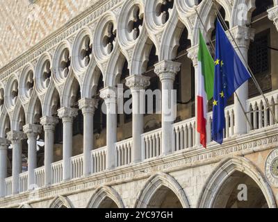 Bandiere italiane ed europee sono appese dalla loggia del Palazzo Ducale sopra la galleria al piano terra, Venezia, Veneto, Italia, Europa Foto Stock