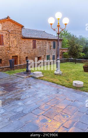 Lampione con riflessioni sul selciato in un villaggio italiano Foto Stock