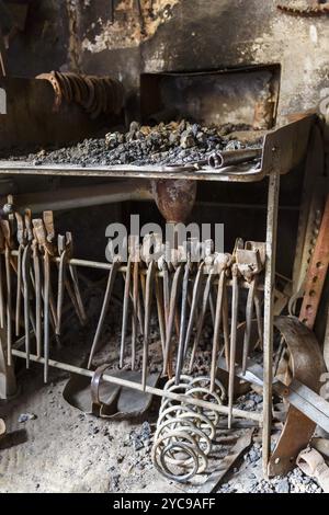 Forge con un focolare e la vecchia pinza in un workshop Foto Stock