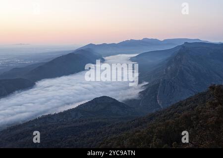 Nuvole nella valle e nel Wonderland Range all'alba fotografate dal Boroka Lookout nei Grampians, Victoria, Australia, Oceania Foto Stock