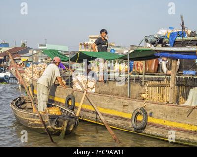 I locali commerciano merci dalle loro barche nel mercato galleggiante sul delta del fiume Mekong, Cai Rang, Vietnam, Asia Foto Stock