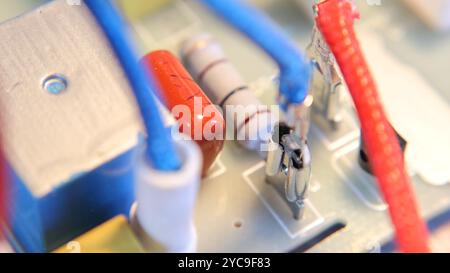 Vari condensatori si concentrano sull'alimentazione della scheda a circuito stampato del primo piano con componenti elettrici Foto Stock