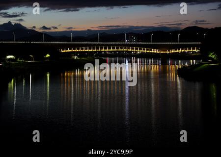 Ulsan, Corea del Sud - 8 ottobre 2023: Il fiume Taehwa riflette il National Garden Bridge illuminato e le sue vibranti luci pedonali, AS Foto Stock