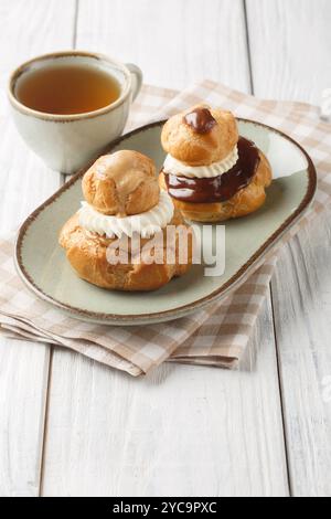 Il Religieuse profiteroles è una pasticceria francese composta da due dolci choux, uno più grande dell'altro, solitamente riempita con il primo piano della crema pasticcera sul piatto Foto Stock