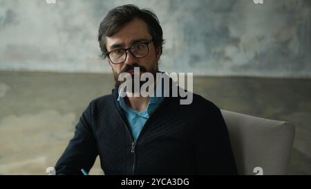 Attento serio Caucasico uomo di mezza età psicologo psicoterapeuta maschile in occhiali da vista ascolto paziente ascoltare cliente scrivere note scrivere Foto Stock