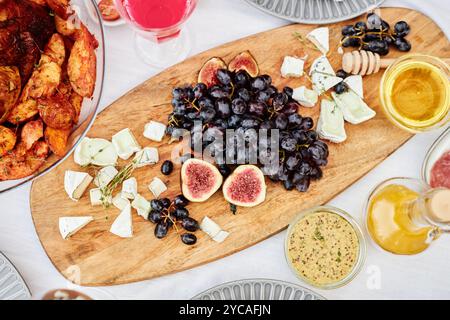 Vista dall'alto, immagine di sfondo di salumi in legno con formaggi e spuntini gourmet, fichi e miele su uno spazio per le copie del tavolo delle cene Foto Stock