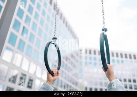 Mani, anello di ginnastica e persona in forma fisica per allenamento, allenamento muscolare o competizione. Primo piano di atleta sospeso, ginnasta forte o acrobata Foto Stock