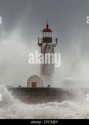 Porto, Portogallo - 7 febbraio 2016: Douro fiume bocca vecchio faro durante la tempesta vedere le persone che scappare dal spruzzi di onde di mare. Foto Stock