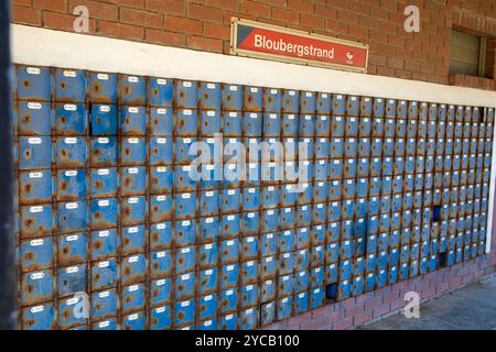 Grande quantità di cassette postali blu presso l'ufficio postale di Bloubergstrand in un sobborgo di città del Capo. Questo è vicino all'oceano, quindi le scatole sono arrugginite. Foto Stock