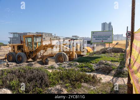 Livellatrice stradale Caterpillar e altre attrezzature da costruzione in un cantiere a Bloubergstrand, città del Capo. Foto Stock