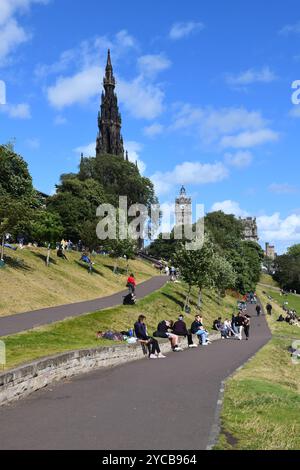 I visitatori si rilassano al sole nei giardini East Princes Street di Edimburgo, Scozia. Foto Stock