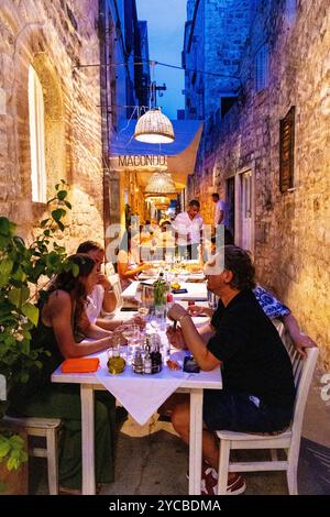 Persone che cenano all'aperto in una strada stretta al ristorante Macondo, isola di Hvar, Croazia Foto Stock