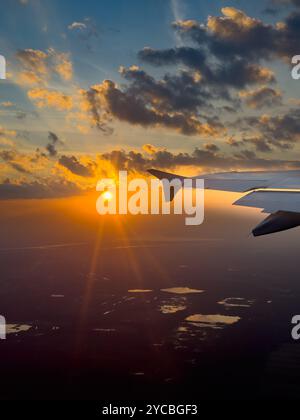 Spettacolare vista al tramonto da un'ala di aeroplani sui paesaggi panoramici durante il volo serale Foto Stock
