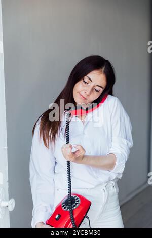 bruna che parla con un vecchio telefono tradizionale Foto Stock