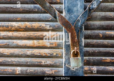 Vecchia serratura ruggine su muro in legno con capanna in legno Foto Stock