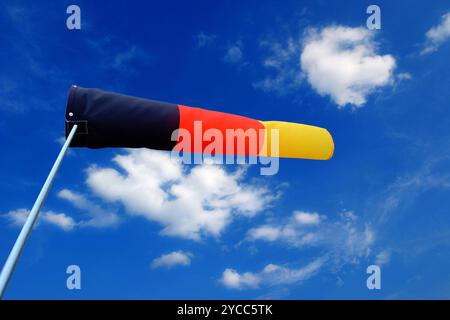 nuvole bianche di cumulus nel cielo blu e una calza a vento tedesca Foto Stock