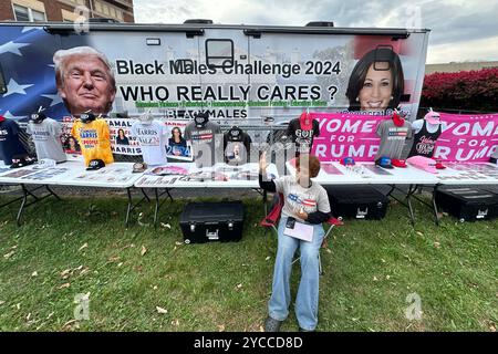 Racine, Wisconsin, Stati Uniti. 22 ottobre 2024. SACARIA FOLWER si occupa dell'autobus "Black Makes Challenge - Who Really Cares" parcheggiato di fronte al municipio di Racine, Wisconsin martedì mattina 22 ottobre 2024, il primo giorno di votazione anticipata nello stato. L'iniziativa ha sede ad Atlanta. Camicie e cappelli per le campagne Harris e Trump sono in vendita. FOWLER ha detto che l'autobus era in servizio tra Michigan e Wisconsin. Il candidato democratico alla vicepresidenza Tim Walz dovrebbe tenere una manifestazione nel centro di Racine in serata. (Credit Image: © Mark Hertzberg/ZUMA Press Wire) UTILIZZO EDITORIALE SU Foto Stock